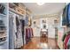Organized walk-in closet with shelves, hanging space, and a vanity with drawers and cabinets at 10937 Sawgrass Dr, Fishers, IN 46037