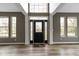 Welcoming foyer featuring gleaming hardwood floors, gray walls, and a striking front door with glass sidelights at 11046 Timberview Dr, Fishers, IN 46037
