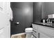 Stylish half bathroom features a black vanity, granite countertop, and sleek fixtures at 11046 Timberview Dr, Fishers, IN 46037
