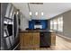 Open kitchen featuring a kitchen island, hardwood floors, and stainless steel refrigerator at 11046 Timberview Dr, Fishers, IN 46037