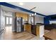 Open kitchen featuring a refrigerator, kitchen island, and hardwood floors leading to the living room at 11046 Timberview Dr, Fishers, IN 46037