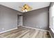 Neutral living room with natural wood floors, an overhead fan, and natural light from a large window at 11046 Timberview Dr, Fishers, IN 46037