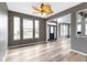 Spacious living room with natural wood-look floors, transom windows, and a dark-stained front door at 11046 Timberview Dr, Fishers, IN 46037