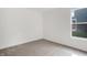 A carpeted bedroom with a window provides a serene, minimalist space at 1255 Thornwood Dr, Greenwood, IN 46143