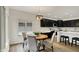 Bright dining area has wooden table, seating for four, and black kitchen cabinets in the background at 12618 E 86Th St, Indianapolis, IN 46236