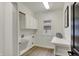 Functional laundry room with cabinets, countertop, utility sink, and window at 12618 E 86Th St, Indianapolis, IN 46236