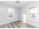 Cozy bedroom with two windows providing ample natural light, complemented by new wood-style flooring at 1302 S Sherman Dr, Indianapolis, IN 46203