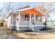 Inviting home showcasing a cozy front porch, gray siding and fresh landscaping, creating curb appeal at 1302 S Sherman Dr, Indianapolis, IN 46203