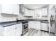 Modern kitchen featuring white cabinets, gray countertops, and stainless steel appliances for a sleek design at 1302 S Sherman Dr, Indianapolis, IN 46203