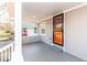 Cozy covered porch with a modern orange security door and ample space to relax and enjoy the outdoors at 1302 S Sherman Dr, Indianapolis, IN 46203