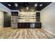 Finished basement bar area with stainless steel appliances, dark wood cabinets, and stone backsplash at 14577 Faucet Ln, Fishers, IN 46040