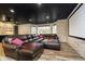 Cozy basement theater setup with large sectional sofa, stone accent wall, and natural light from windows at 14577 Faucet Ln, Fishers, IN 46040