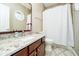Bathroom with granite countertop vanity and patterned shower curtain, with an adjacent toilet at 14577 Faucet Ln, Fishers, IN 46040