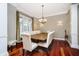 Formal dining room with hardwood floors, chandelier lighting, window views, and elegant upholstered seating at 14577 Faucet Ln, Fishers, IN 46040