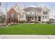 Beautiful two-story home with a well-manicured lawn, red brick facade, and inviting covered front porch at 14577 Faucet Ln, Fishers, IN 46040
