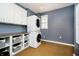 Modern laundry room with stacked washer/dryer, storage, counter space and good lighting at 14577 Faucet Ln, Fishers, IN 46040