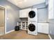 Functional laundry area with stacked washer and dryer, cabinetry, countertop, and a sink at 14577 Faucet Ln, Fishers, IN 46040
