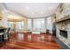 Open-concept living area featuring hardwood floors, a stone fireplace, and large windows for abundant natural light at 14577 Faucet Ln, Fishers, IN 46040