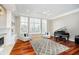 Spacious living room with hardwood floors, natural light, fireplace, and cozy seating by the large windows at 14577 Faucet Ln, Fishers, IN 46040