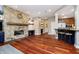 Open living room features a stone fireplace, hardwood floors, and seamless flow into the kitchen at 14577 Faucet Ln, Fishers, IN 46040