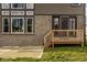 Backyard view features a small wooden deck with stairs and brick exterior of the home at 14818 Autumn View Way, Fishers, IN 46037