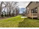 Backyard featuring green grass, a two-story house exterior, a wooden deck, and mature trees at 14818 Autumn View Way, Fishers, IN 46037