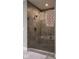 Modern bathroom shower with seamless glass doors and gray tile, complemented by a built-in bench and neutral towels at 14818 Autumn View Way, Fishers, IN 46037