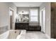 Elegant bathroom featuring a soaking tub, granite vanity, and tiled shower, designed for relaxation and comfort at 14818 Autumn View Way, Fishers, IN 46037