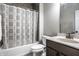 Well-lit bathroom featuring a shower-tub combo with gray pattern curtain, toilet and vanity, offering a clean and functional space at 14818 Autumn View Way, Fishers, IN 46037
