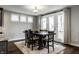 A modern dining area features a stylish table with seating for six, a textured rug, and natural light from nearby windows at 14818 Autumn View Way, Fishers, IN 46037