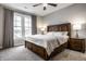 Comfortable bedroom with large window, wooden headboard bed, side tables, and grey curtains creating a relaxing retreat at 14818 Autumn View Way, Fishers, IN 46037