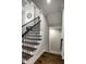 Elegant staircase with dark wood steps, a black metal railing, and white trim, leading to the upper level of the home at 14818 Autumn View Way, Fishers, IN 46037