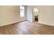 Bright bedroom features wood flooring, white trim, natural light, and an adjacent bathroom at 1518 Lawton Ave, Indianapolis, IN 46203