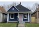 Charming blue house with white trim, gray steps and a pink front door at 1518 Lawton Ave, Indianapolis, IN 46203