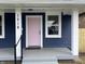 Front porch and pink front door of blue house with white trim and gray steps at 1518 Lawton Ave, Indianapolis, IN 46203