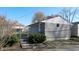 View of backyard and exterior of a house with grey stone, shingle siding, fence, and spring greenery at 1521 Pleasant St, Indianapolis, IN 46203