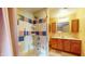 The bathroom has a shower and tub, vanity with wood cabinets, and colorful tiles at 1521 Pleasant St, Indianapolis, IN 46203