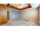 Spacious bedroom features a ceiling fan, wood paneled accent wall, and carpeted floors at 1521 Pleasant St, Indianapolis, IN 46203