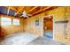 Unfinished garage interior with exposed rafters, ceiling fan, concrete floor, and access to another room at 1521 Pleasant St, Indianapolis, IN 46203