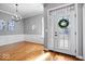 Elegant foyer with hardwood floors, a decorative chandelier, and a glass-paneled front door with sidelights at 17279 Crescent Moon Dr, Noblesville, IN 46060