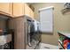 This laundry room includes modern front load washer and dryer with upper cabinets and window for natural light at 17279 Crescent Moon Dr, Noblesville, IN 46060