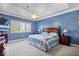 Tranquil main bedroom with blue walls, a tray ceiling, and a large window at 17279 Crescent Moon Dr, Noblesville, IN 46060