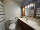 Well-lit bathroom features a toilet, patterned shower curtain, and a wood-trimmed vanity at 2115 Leonard Rd, Martinsville, IN 46151