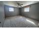 This image displays a bedroom with a ceiling fan, windows, and carpeted flooring at 2115 Leonard Rd, Martinsville, IN 46151