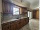 Kitchen features wood cabinets, double sink, tile backsplash and view of sunroom at 2115 Leonard Rd, Martinsville, IN 46151