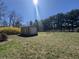 This image shows a backyard shed with a roll-up door, situated on a well-maintained grass lawn at 2115 Leonard Rd, Martinsville, IN 46151