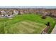 Aerial view of the well-maintained community, showing a manicured lawn, trees, and community basketball court at 307 Baywood Ct # 67, Noblesville, IN 46062