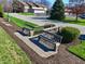 Inviting outdoor seating area with benches, surrounded by well-kept landscaping and a glimpse of neighborhood streets at 307 Baywood Ct # 67, Noblesville, IN 46062