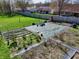 Aerial shot of a backyard, displaying a green covered area with garden beds, surrounded by a fence and lush green space at 307 Baywood Ct # 67, Noblesville, IN 46062