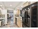Bright kitchen with light wood cabinets, black refrigerator, and an open view to the dining and living areas at 307 Baywood Ct # 67, Noblesville, IN 46062